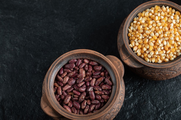 Ancient pot with uncooked kidney beans and popcorn