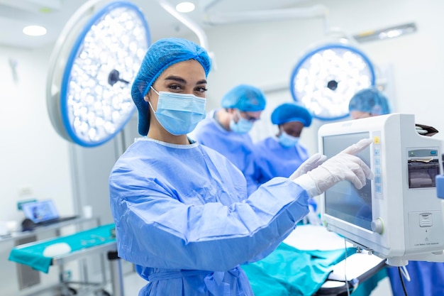 Anesthesiologist keeping track of vital functions of the body during cardiac surgery Surgeon looking at medical monitor during surgery Doctor checking monitor for patient health status