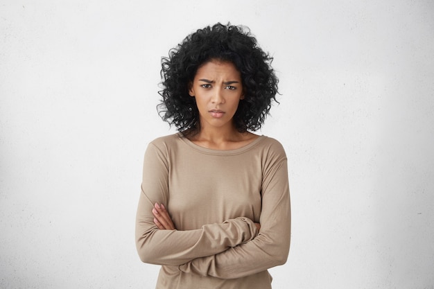 Angry annoyed young housewife keeping arms crossed