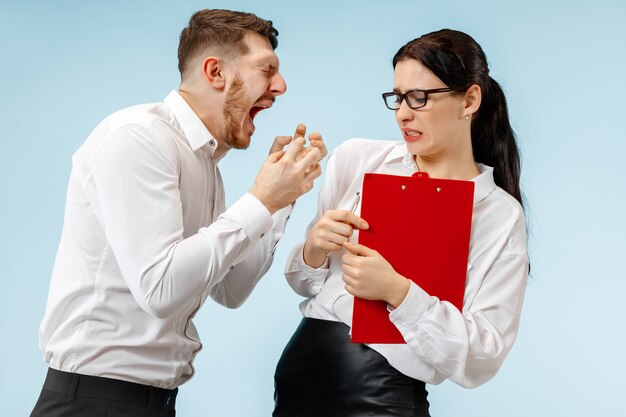 Angry boss. Man and his secretary standing at office or studio. Business man screaming to his colleague. Female and male caucasian models. Office relationships concept, Human emotions