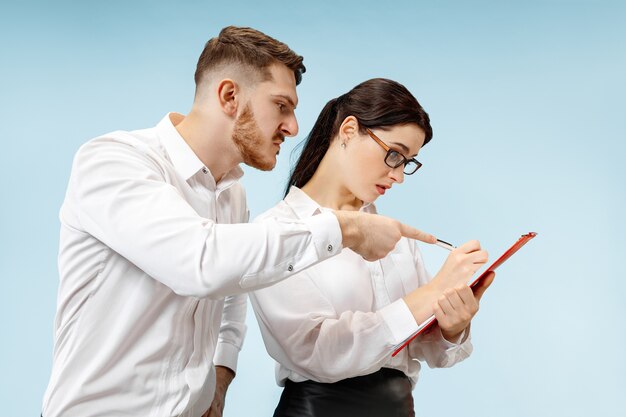 Angry boss. Man and his secretary standing at office or studio. Business man screaming to his colleague. Female and male caucasian models. Office relationships concept, Human emotions