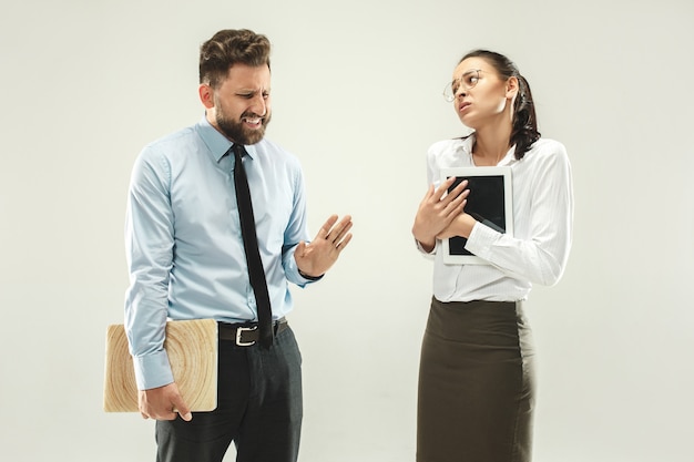 Angry boss. Man and his secretary standing at office 