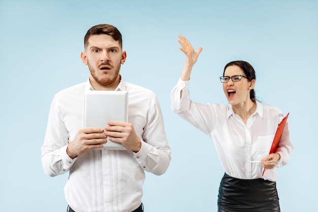 Angry boss. woman and his secretary standing at office or studio.