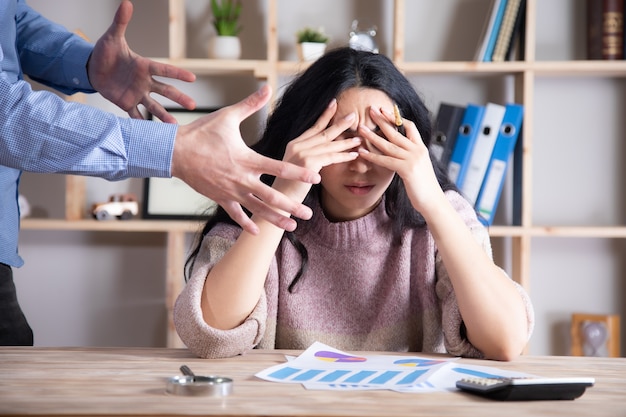 Angry business man with sad woman in office