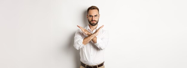 Angry businessman frowning and showing cross stop you telling no and prohibit something standing ove