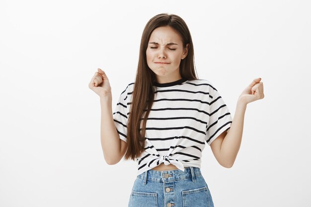 Angry and cute young adorable girl looking mad, clench fists aggressive