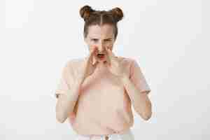 Free photo angry disappointed redhead teenage girl posing against the white wall