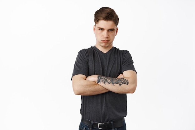 Free photo angry and displeased young man feel offended cross arms on chest defensive sulking and frowning bothered standing upset against white background