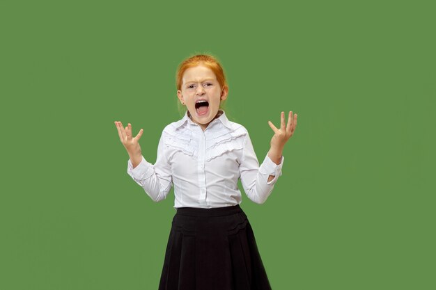 Angry emotional girl screaming isolated on green wall