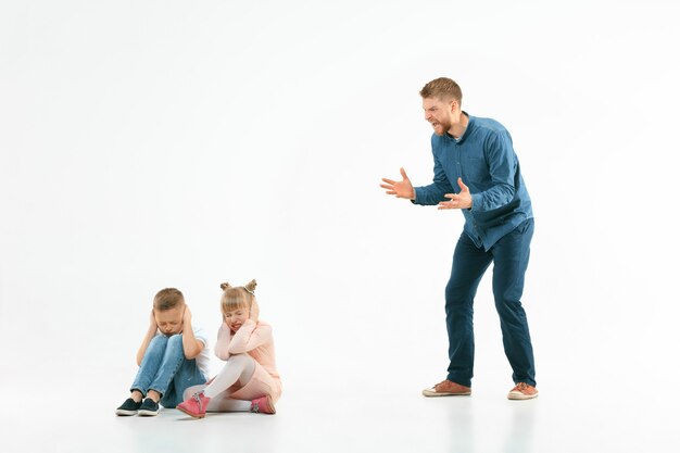 怒った父親が息子と娘を家で叱る。