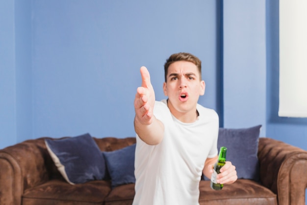 Free photo angry football fan in front of couch