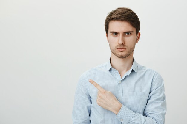 Angry frustrated man with bristle pointing finger upper left corner