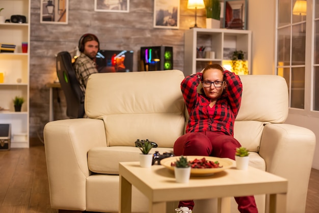 Free photo angry and frustrated woman gamer playing video games on the console late at night in the living room