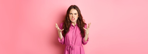 Free photo angry and furious young woman shaking hands looks frustrated and outraged arguing complaining on som