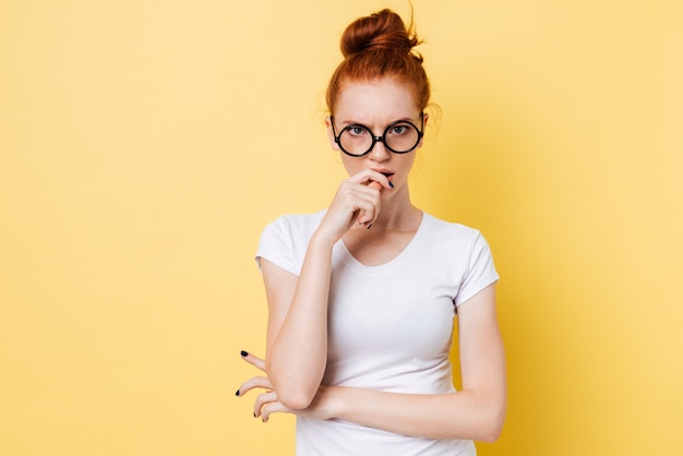 Angry ginger woman in eyeglasses looking