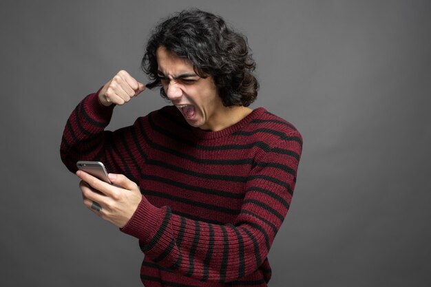 Foto gratuita ragazzo arrabbiato mentre parla con il telefono