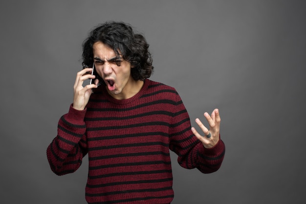 Angry guy while speaks with phone