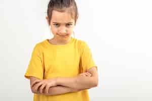 Free photo angry little girl with folded hands on a white background isolated