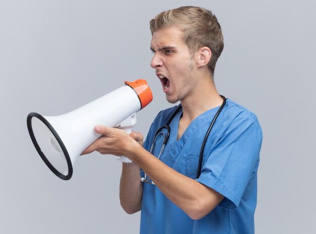 聴診器で医者の制服を着ている側の若い男性医師を見て怒っている白い壁に分離されたスピーカーで話します