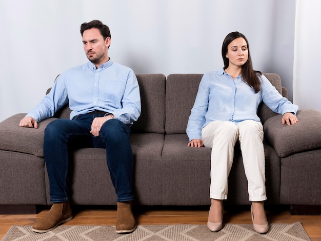 Free photo angry male and woman sitting on the couch