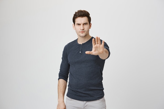 Angry man extend hand, showing stop gesture, prohibit or warn