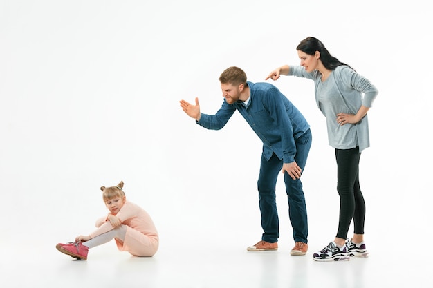 Angry parents scolding their daughter at home.