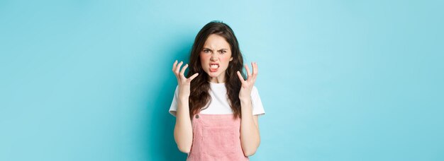 Angry and pissedoff brunette woman shaking hands and frowning outraged look with hatred standing fur