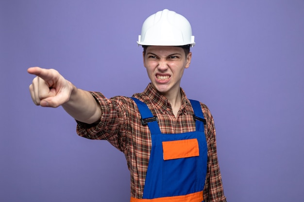 Free photo angry points at front young male builder wearing uniform