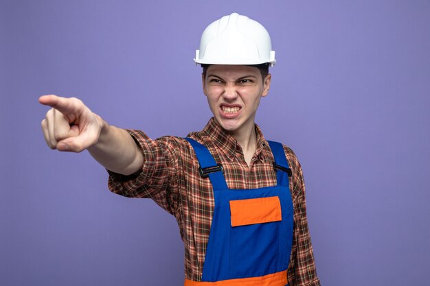 Angry points at front young male builder wearing uniform