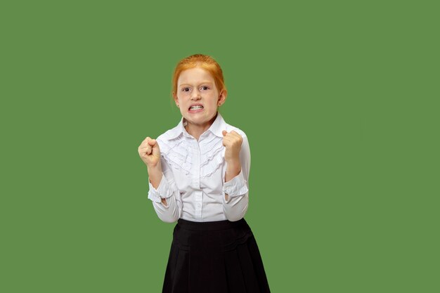 Angry red-haired girl standing on trendy green wall