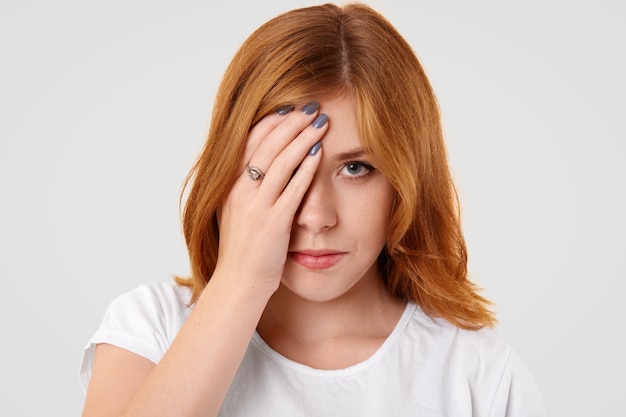 Angry sad female covers half of face after quarrel with boyfriend