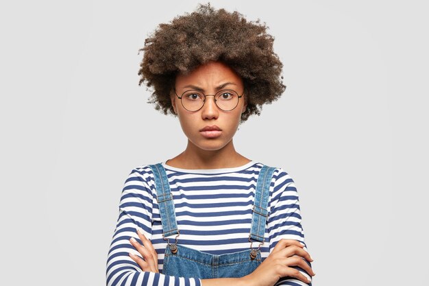 Angry serious African American female student keeps arms folded