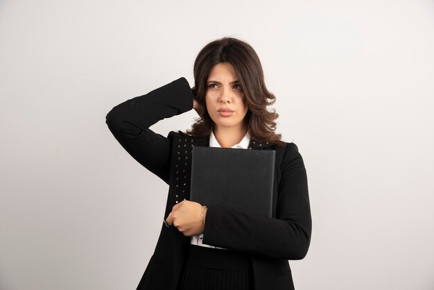 Angry teacher holding book on white.