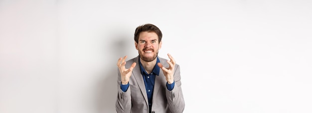 Free photo angry and tensed businessman wants to kill someone clenching hands and teeth looking mad at camera g
