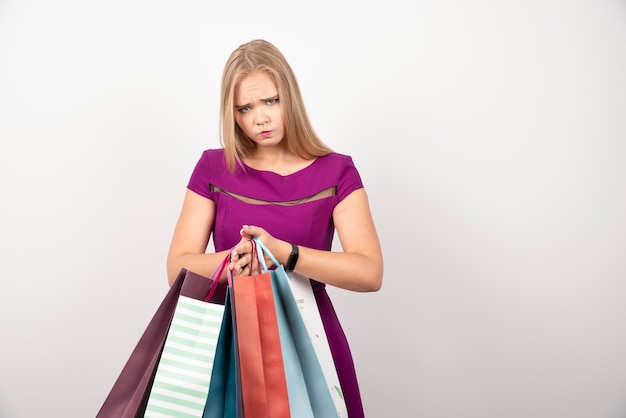Angry woman holding bunch of shopping bags. High quality photo