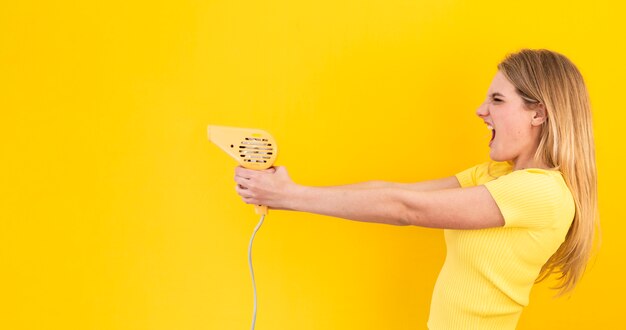 Angry woman holding hair dryer