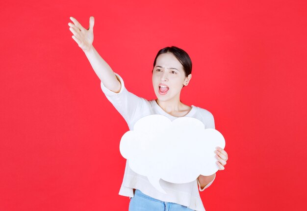 Angry woman holding speech bubble with a cloud shape