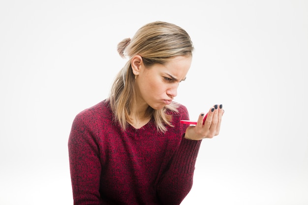 Angry woman looking in small mirror