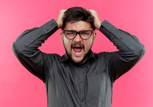 Angry young businessman wearing glasses grabbed head 