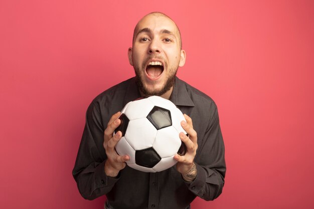 Angry young handsome guy holding ball