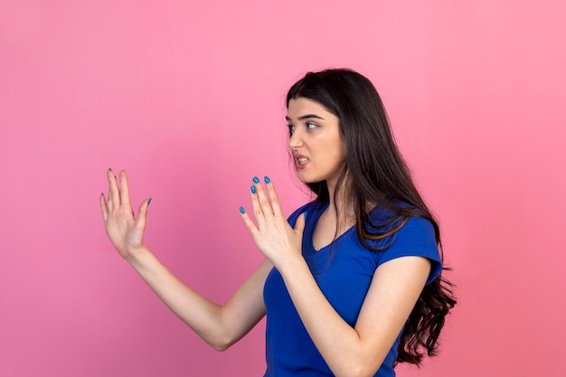 Angry young lady is ready to fight on pink background High quality photo