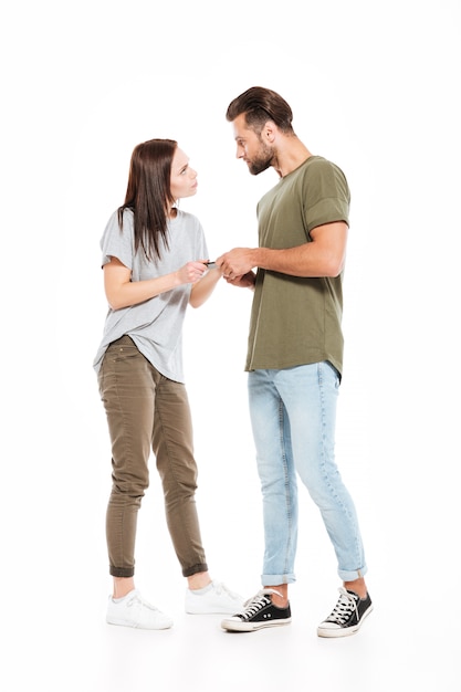 Angry young loving couple holding phone.