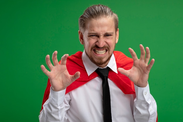 Free photo angry young superhero guy showing tiger style gesture isolated on green