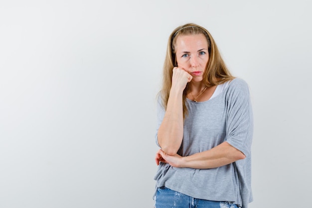 The angry young woamn is holding her hand on cheek  on white background