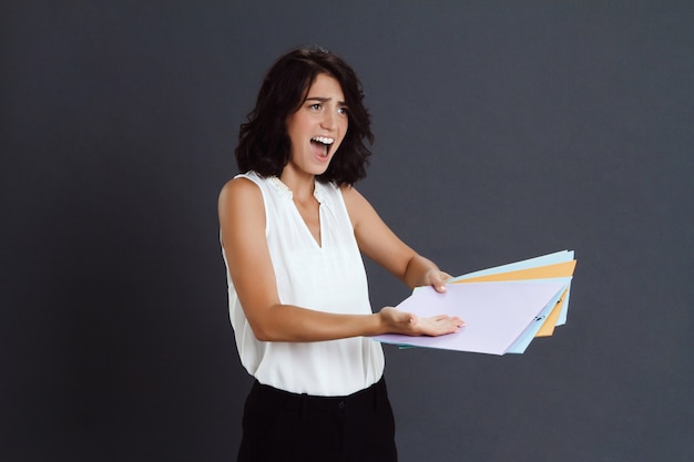 Free photo angry young woman holding documents in hands