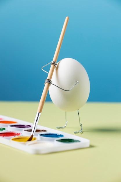 Free photo animated egg holding brush still life