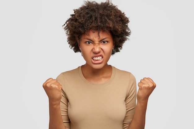 Foto gratuita la donna afroamericana infastidita stringe denti e pugni, essendo irritata