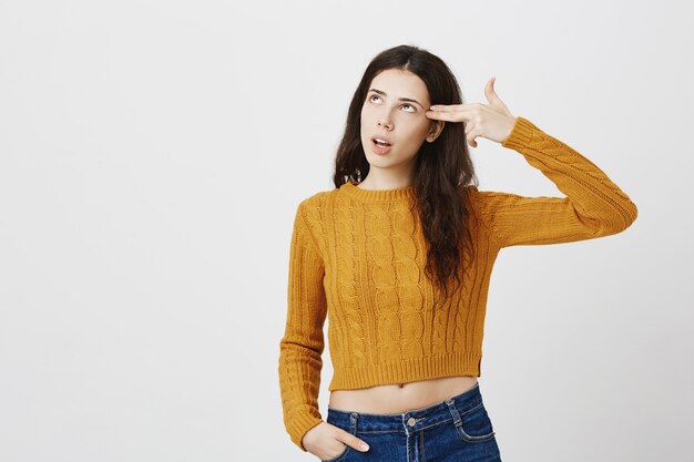 Annoyed or bothered girl eye roll and making gun shooting gesture over head