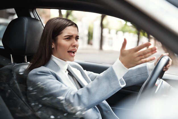 Annoyed businesswoman stuck in traffic on her commute.