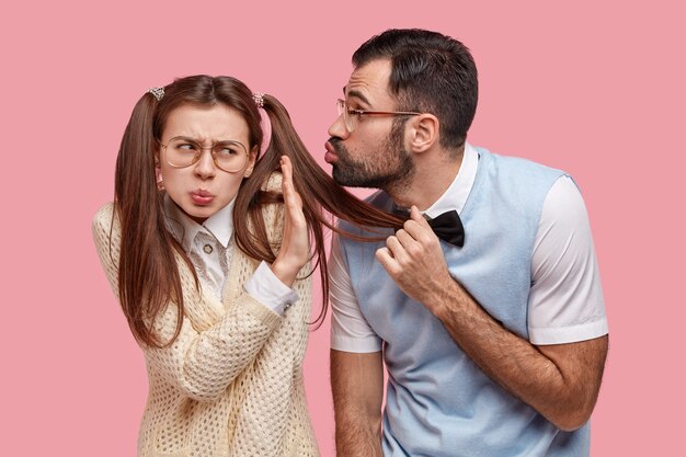 Annoyed displeased schoolgirl shows no sign, refuses recieving kiss from classmate wonk